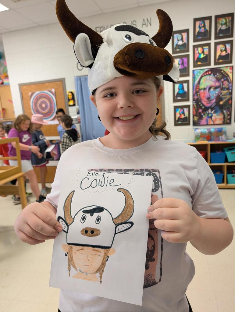 There is a girl holding up a picture of a girl with a cow hat on.  The girl also has a cow hat on.
