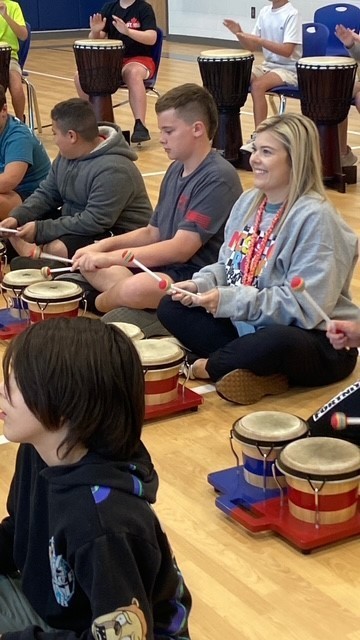Students playing drums during the presentation.
