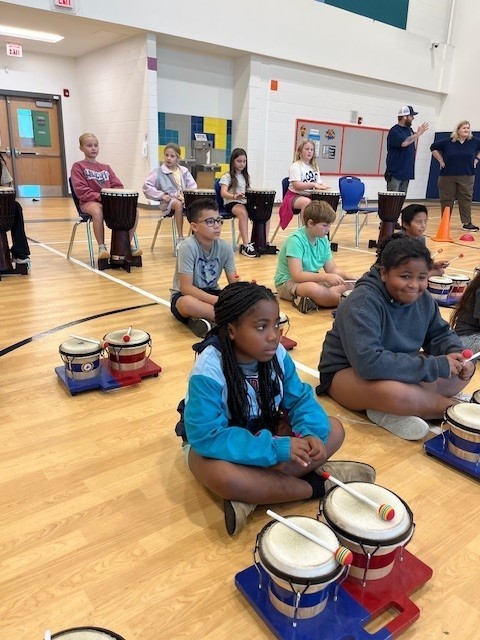 Students listening to the dancing drum presenter.