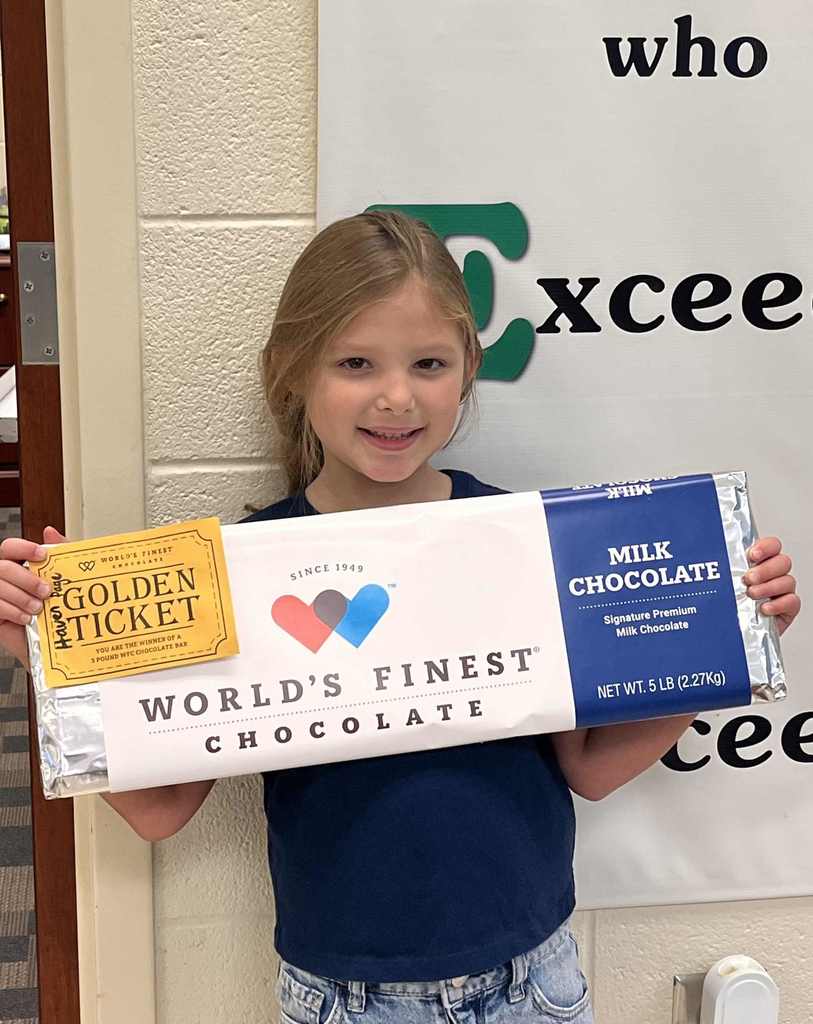 Smiling young girl holding a 5 pound bar of chocolate