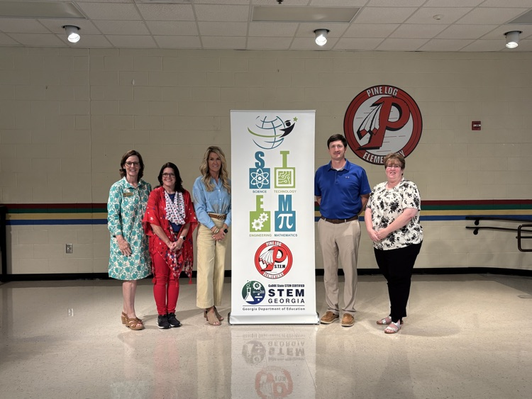 people standing in front of a stem banner