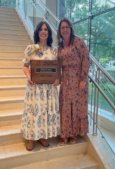 Our teacher of the year and principal smiling for a picture at the Booth Museum.