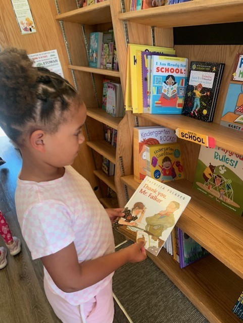 girl looking at a book in the book mobile