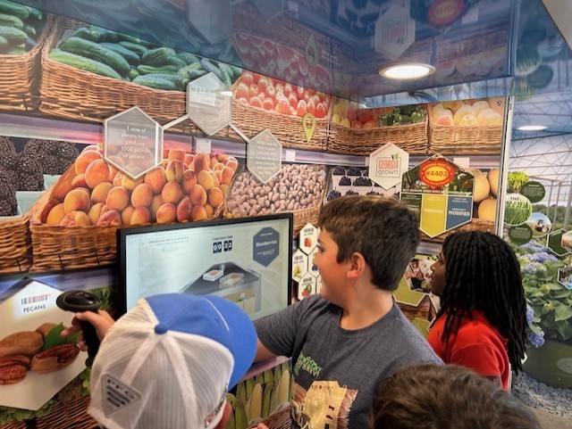 Our 3–5 students had an exciting visit from Georgia Farm Bureau and their mobile Georgia Ag Experience!  This 36-foot mobile classroom showcases Georgia agriculture on the road, visiting elementary schools and community organizations across the state. Inside, students explored seven different Georgia agricultural commodities through technology and digital learning.   The Georgia Ag Experience is a STEM-based program that invites students across Georgia to discover the vast opportunities in agriculture. It connects science, technology, and real-world farming in a way that brings learning to life for our students and helps them think about possible future careers in the agricultural field, from farming and animal science to technology and engineering.   A special shoutout to Gaines Beef for joining us with the Ag Mobile. They also partner with our School Nutrition team to provide fresh beef to our schools, and we are so grateful for their support.