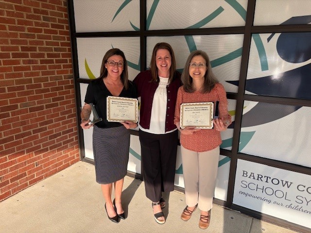 Mrs. Guyton and Mrs. Novo smiling for a picture after receiving the award in math at the county office.