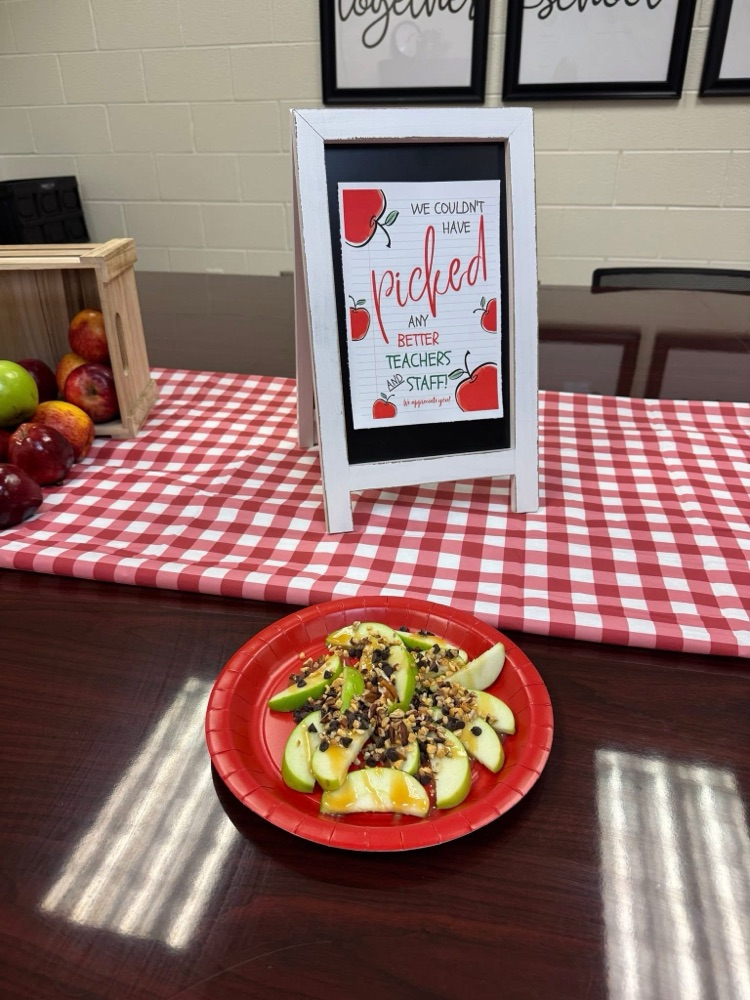 table with crates of apples, red checkered table cloth, a variety of toppings! 