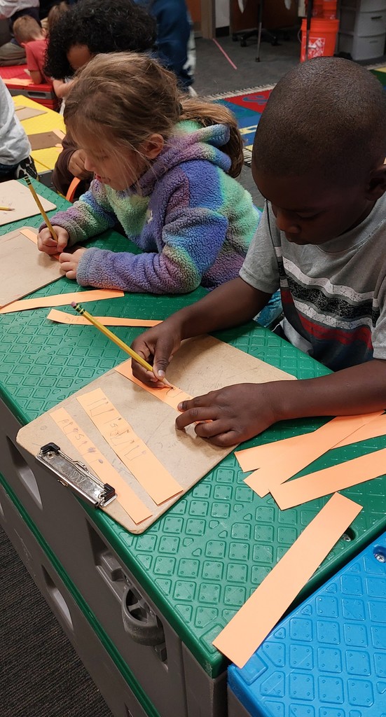 A girl and a boy are tracking strips to make their pumpkins.