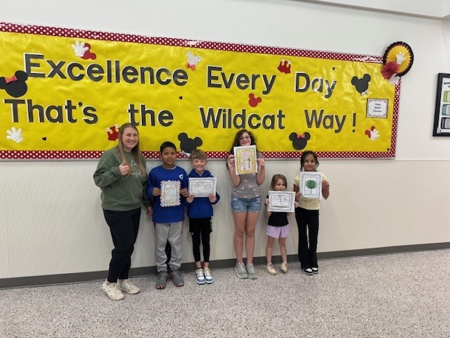 Students smiling for a picture for winning the attendance art contest.