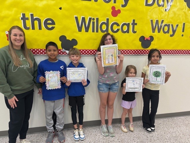 Students smiling for a picture for winning the attendance art contest.