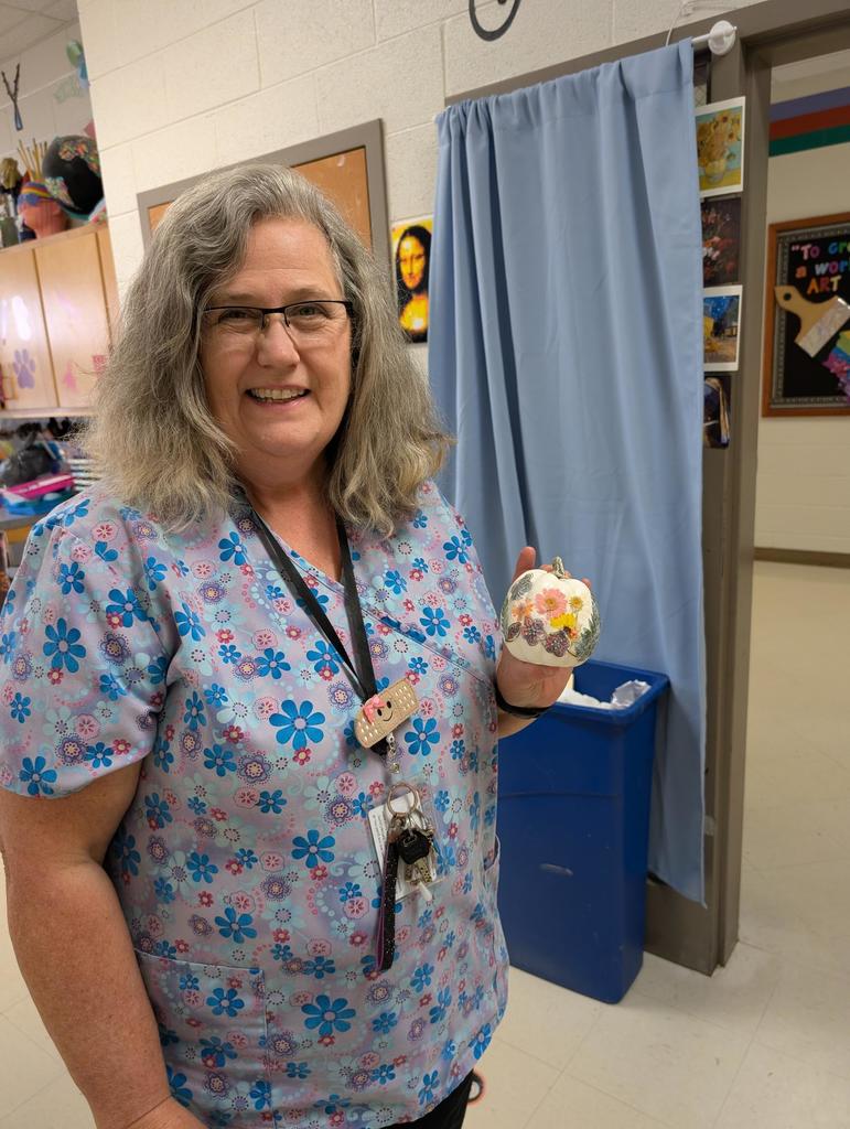 a nurse holding up her decorated pumpkin