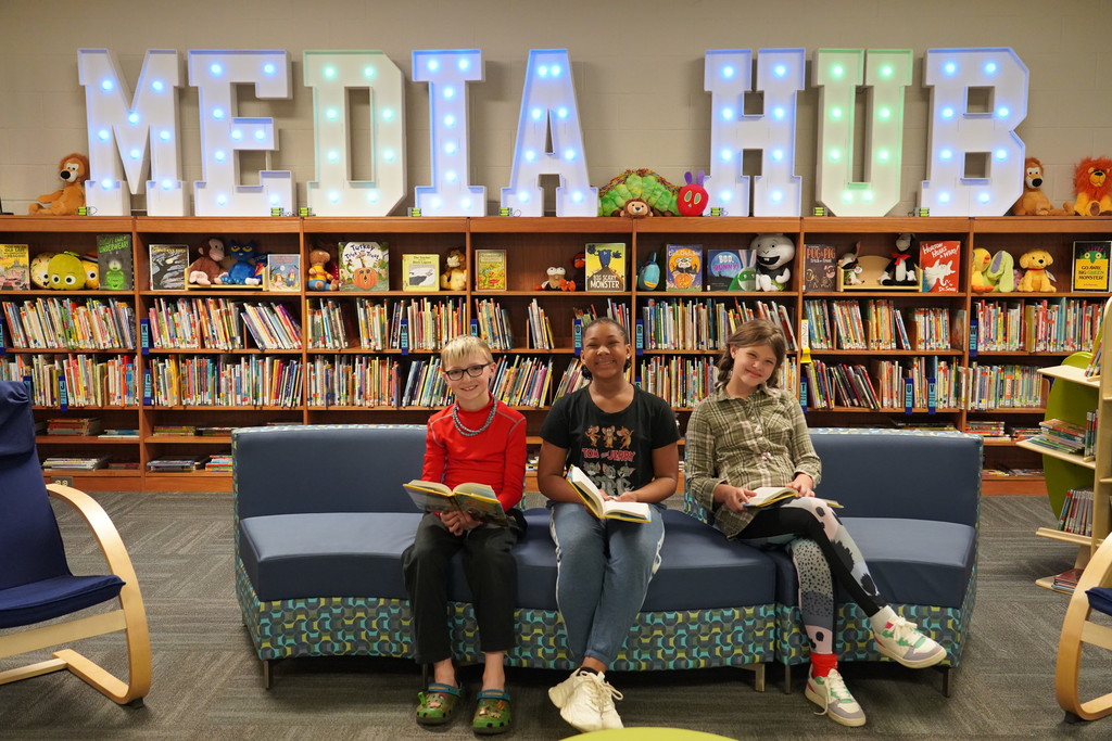 Clear Creek students in media Hub reading a book