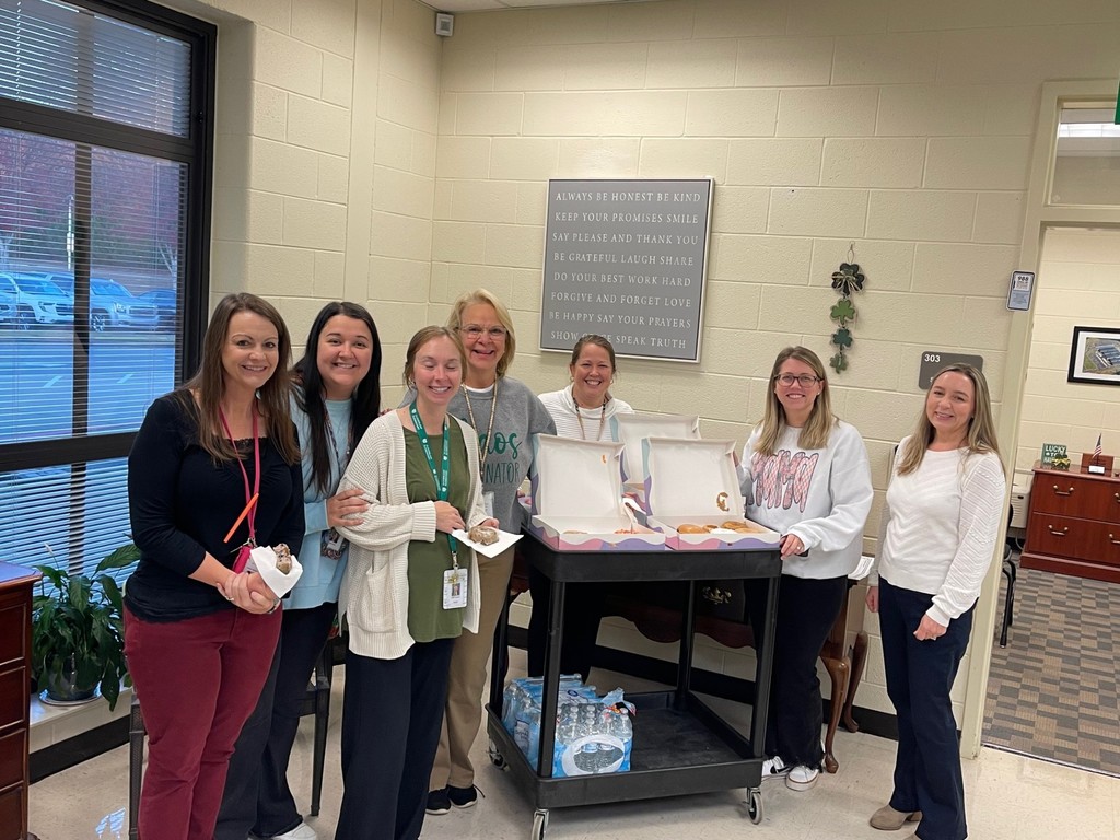 Smiling teachers gathered around the donut cart