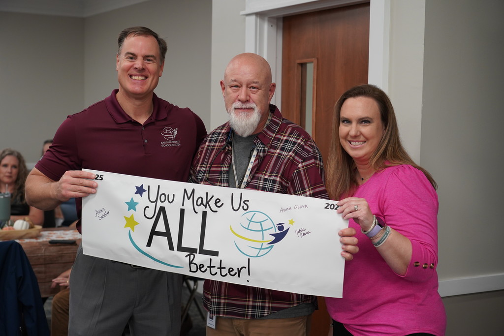 central office staff members holding a banner