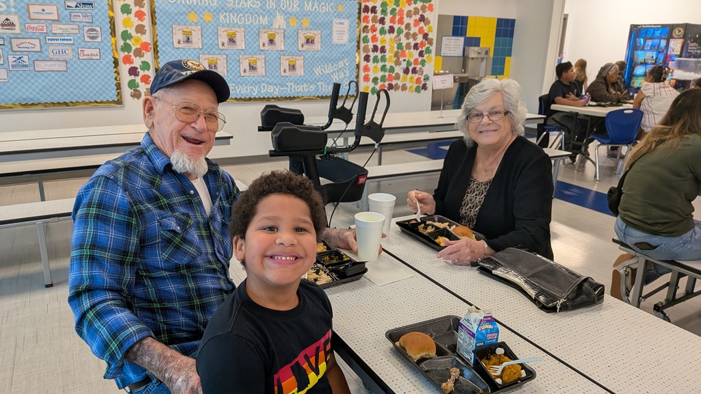 Families smiling and eating thanksgiving lunch.