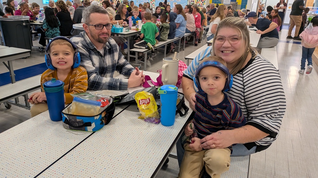 Families smiling and eating thanksgiving lunch.