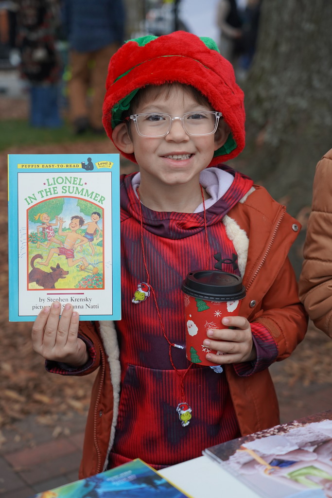 child holding book at christmas parade