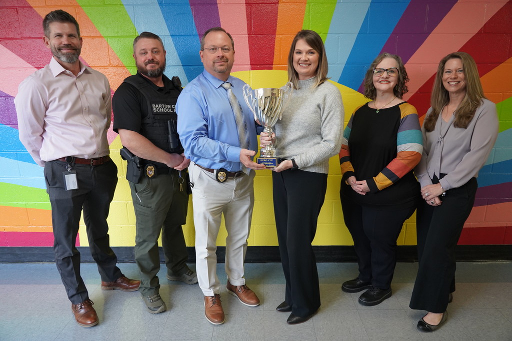 Hamilton Crossing Elementary admin posing with hero cup trophy