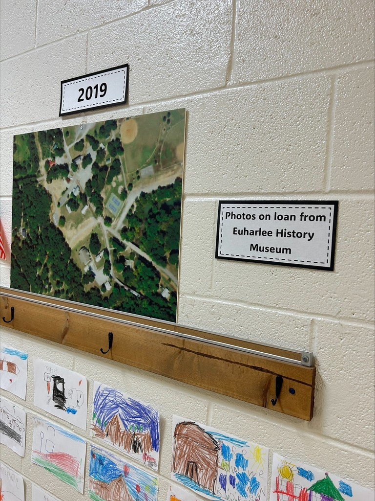 There is a caption that says, "America Then and Now".  There are aerial photos of the school.  Under those photos are student drawings.