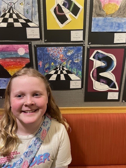 Student smiling for a picture at the art show.