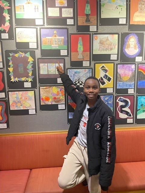 Student smiling for a picture at the art show.