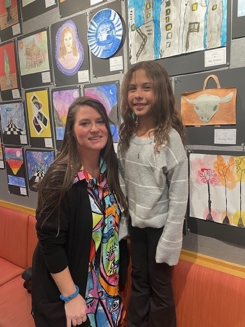Mrs. Nix and a student smiling for a picture at the art show.