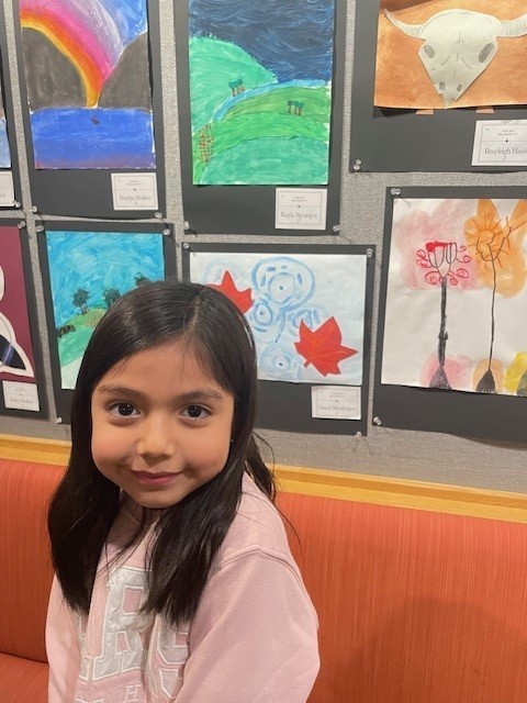 Student smiling for a  picture at the art show. 