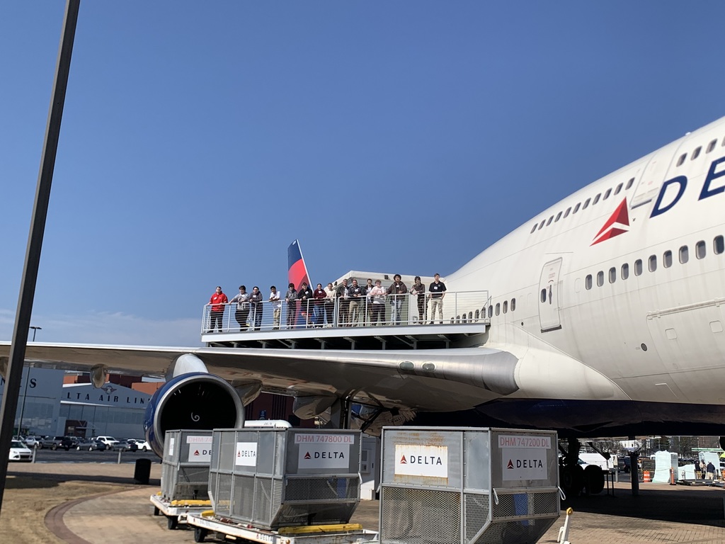 CTAE students standing on a platform on a wing of a Delta plane