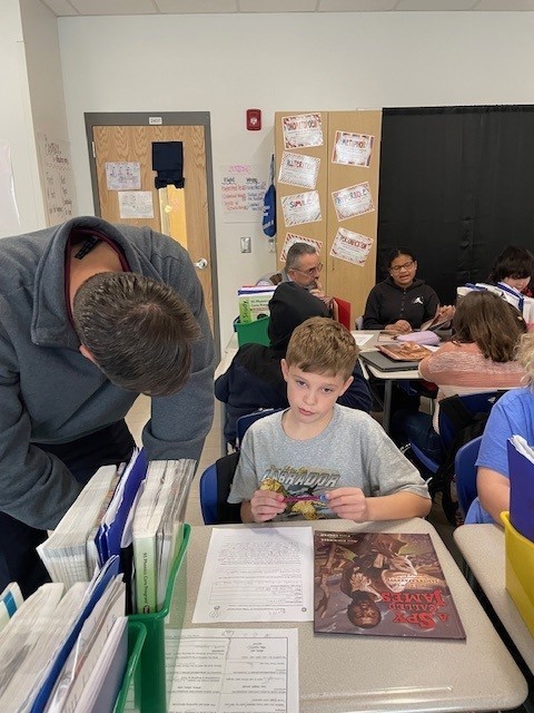Mr. Emerson talking to a fourth grade student about her writing. 