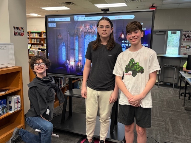 3 students in front of tv screen