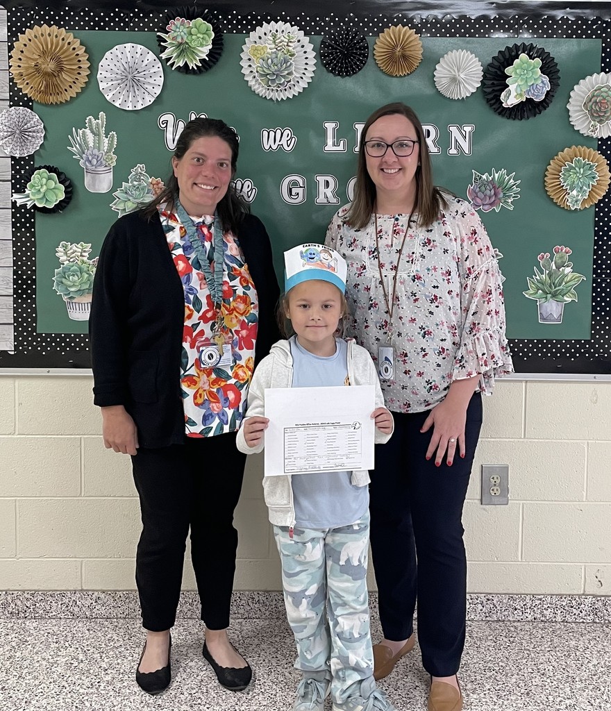 Principal Mrs. LaRue and Assistant Principal Dr. Payne stand with a girl who is holding a positive office referral. 