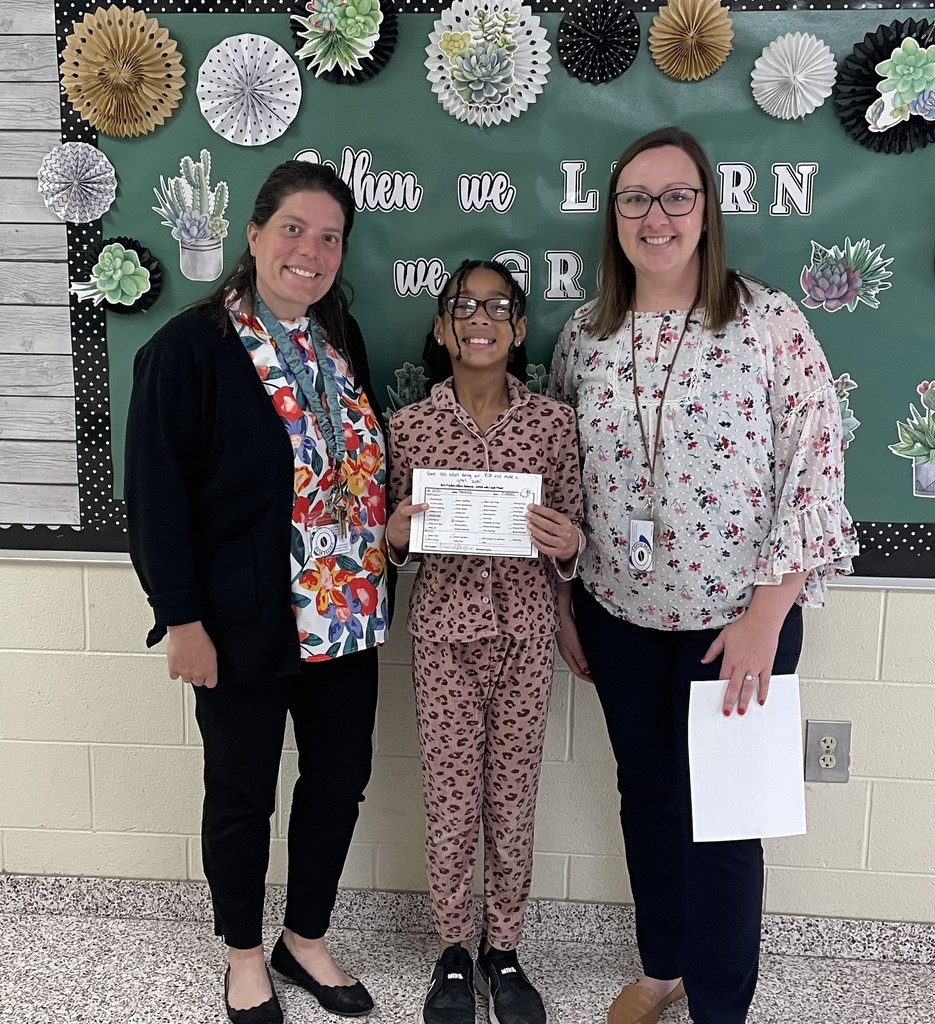 Principal Mrs. LaRue and Assistant Principal Dr. Payne stand with a girl who is holding a positive office referral.