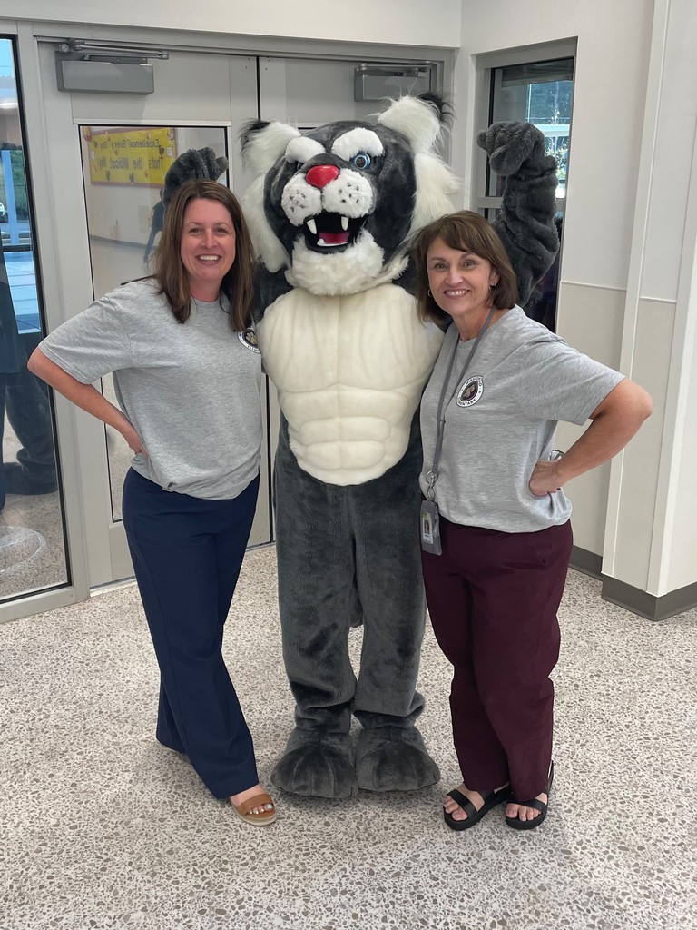 principals standing with wildcat scratch