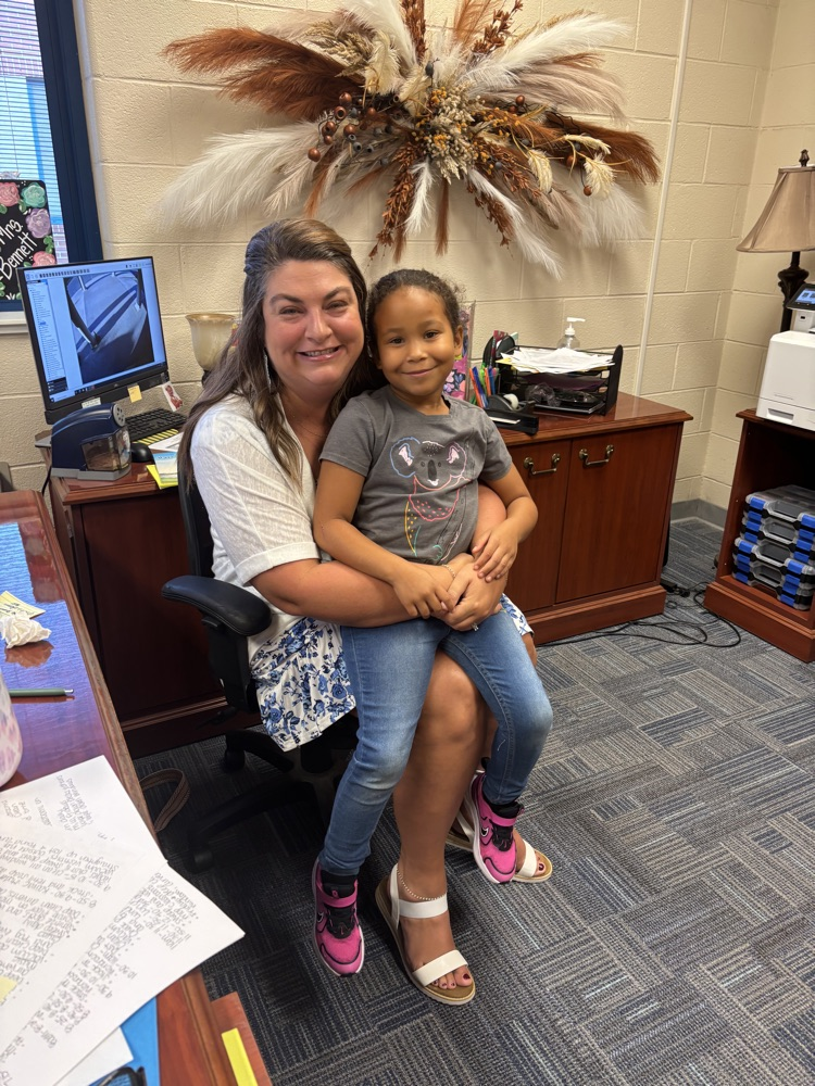 Mrs. Bennett sitting in a chair with a student