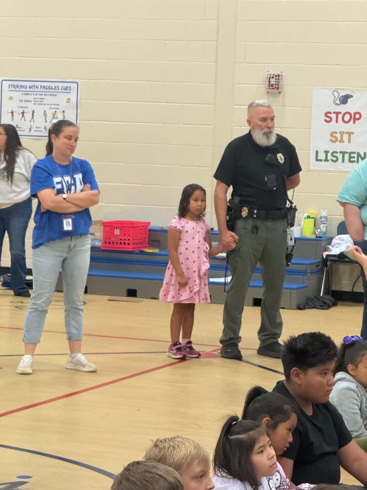 two adults and some children watching something