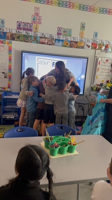 Ms. Zimmerman getting hugs from her students after the announcement of her being named Teacher of the Year