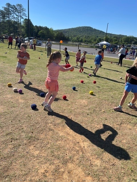 A student playing with a foam ball to hit it over the net. 