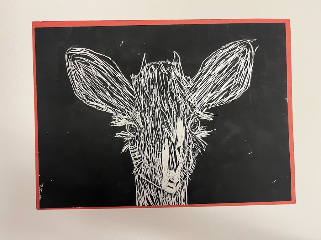 This piece of art work features a drawing of a deer's head on a black background. It has a white outline and detailed features.