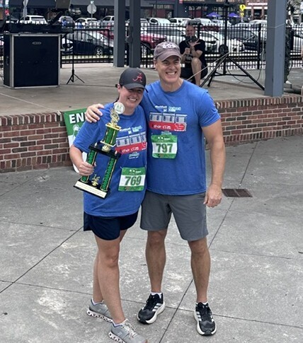 Mrs. Stephens and Mr. Terza smiling for a picture after MRES won the 5K trophy.