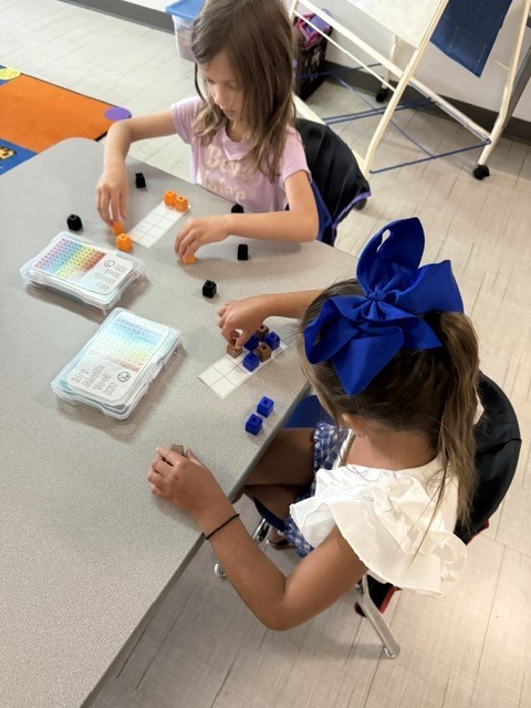 Kindergarten students using blocks to show numbers on a ten frame.