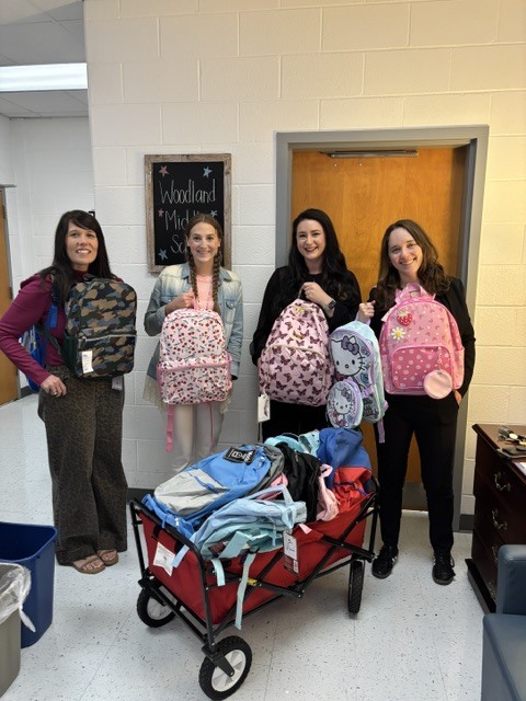 Students and counselors showing supplies that were donated.