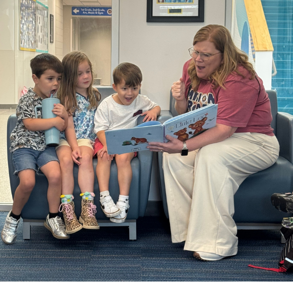 Mrs. Ristroph reading to students and they are smiling. 