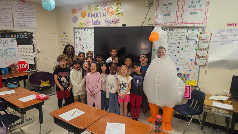 Mrs. Dedra spins the attendance wheel for Mrs. Kimberly's homeroom.