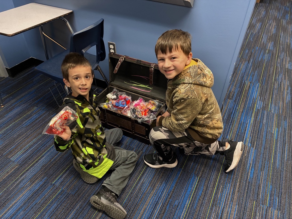 two students getting prizes from the treasure chest