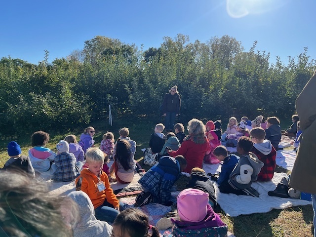 students sitting at the apple orchard