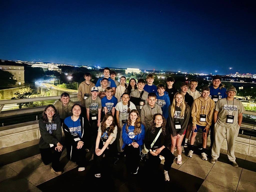 Students standing for group picture with the skyline of Washington DC in the background