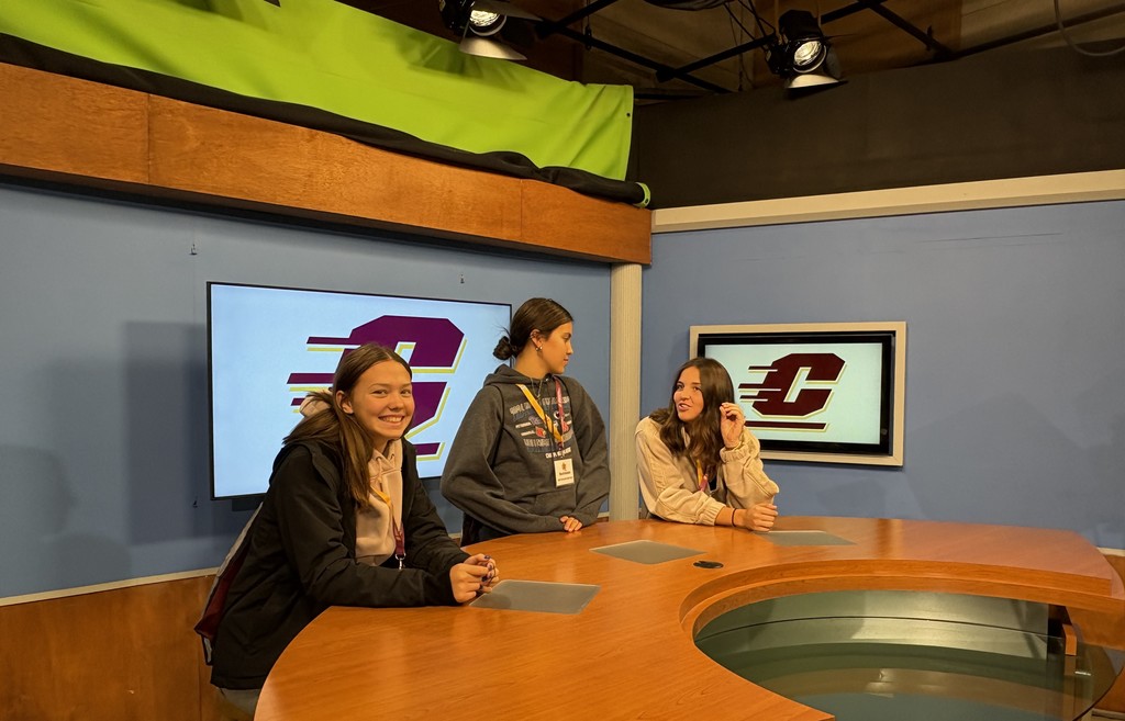 Girls sitting at news desk