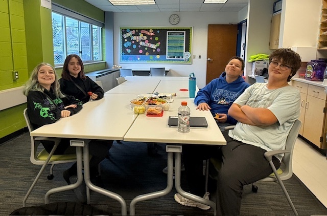 Four students sitting around a lunch table. 