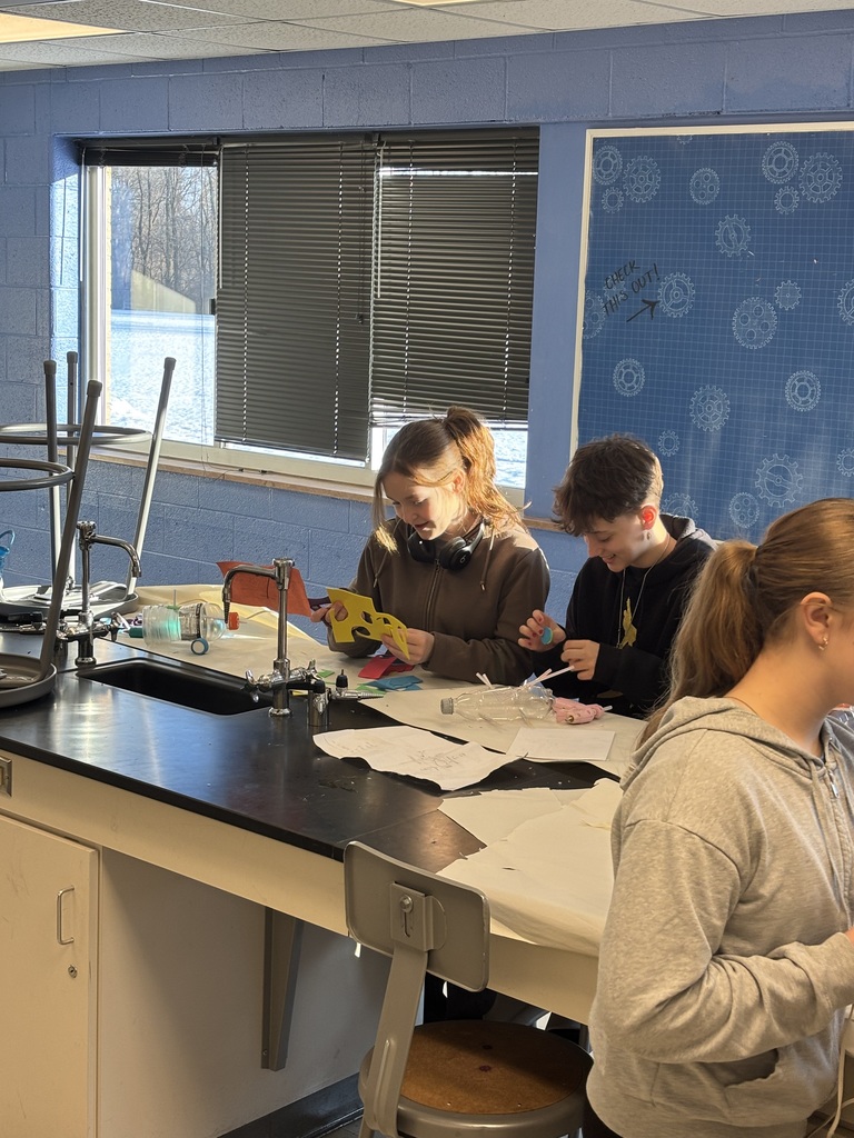 Students sitting at a table working on a science project.