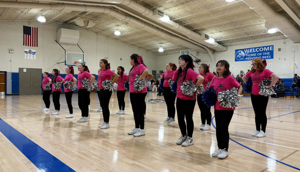 Cheerleaders cheering on a basketball court.