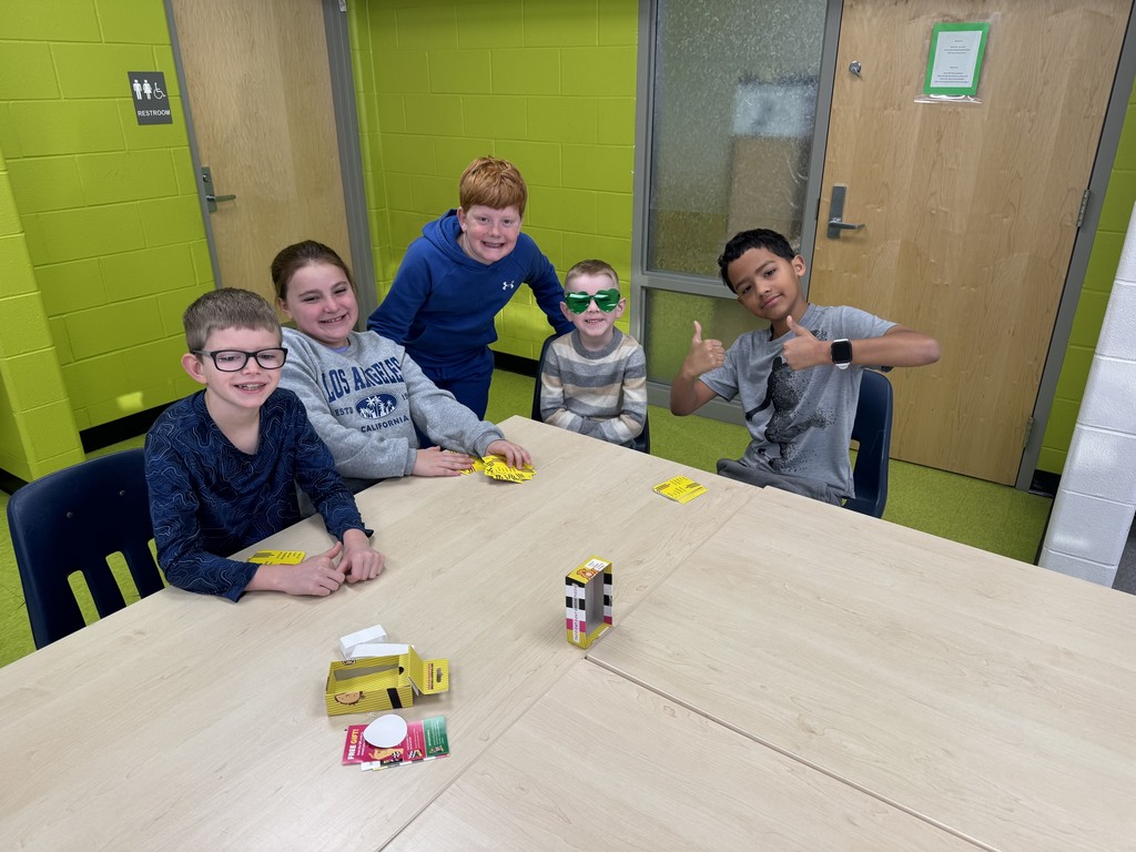 Students sitting at a table playing a card game